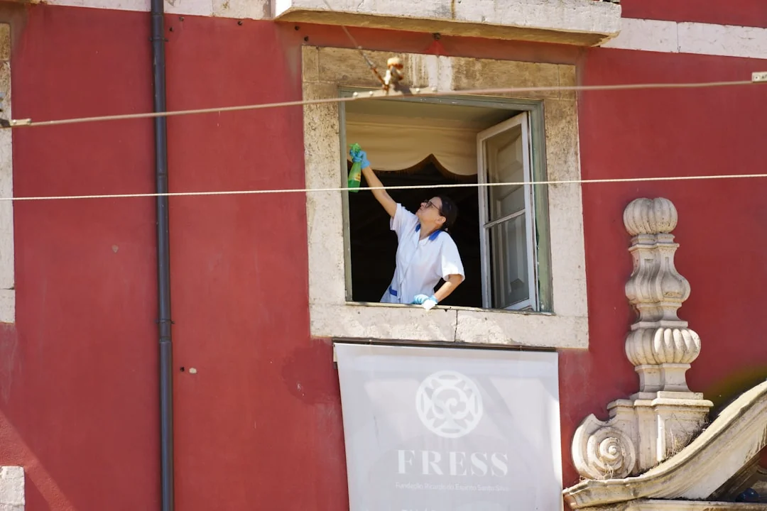 Side view of young ethnic male in uniform cleaning floor with mop while working in retro styled restaurant